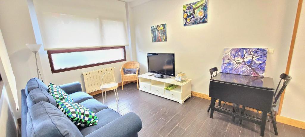 a living room with a blue couch and a flat screen tv at Santana Apartment Metro in Las Arenas