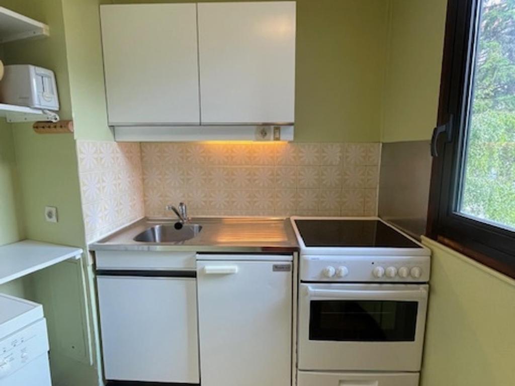 Il comprend une petite cuisine équipée d'une cuisinière et d'un évier. dans l'établissement Appartement cosy 2 pièces, 5 pers, balcon, wifi, animaux admis, quartier Croisette - FR-1-574-68, aux Menuires