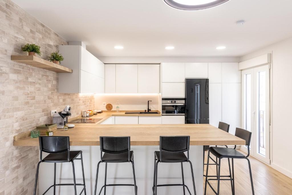 a kitchen with a large wooden table and black chairs at Jardinillos Bed & Parking in Jaén