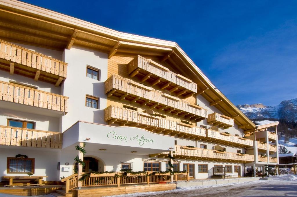 a hotel with wooden balconies on the side of a building at Family and Wellness Residence Ciasa Antersies in San Cassiano