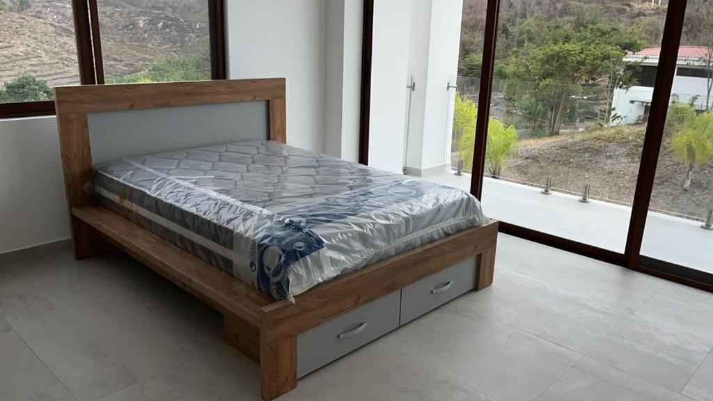 ハマにあるLujoso departamento Jama Manabí con vista al Marの大きな窓付きの客室の木製ベッド1台分です。