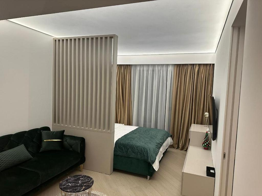 a small bedroom with a bed and a couch at Happy Studio Luxury Cortina North in Voluntari