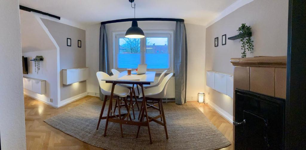 a dining room with a table and chairs and a window at Ferienwohnung Soltau Parkplatz, Dachterrasse, Klimaanlage, 5 Gäste in Soltau