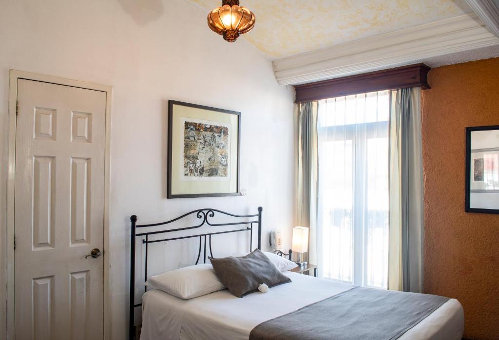 Postel nebo postele na pokoji v ubytování Pórtico Hotel & Galería
