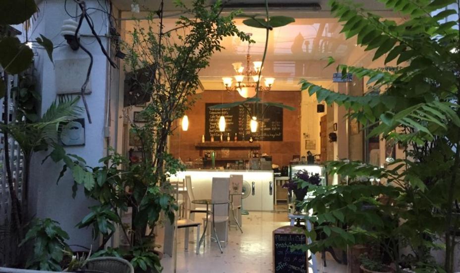 une cuisine avec une table, des chaises et des plantes dans l'établissement Oriental Smile Hotel, à Bangkok