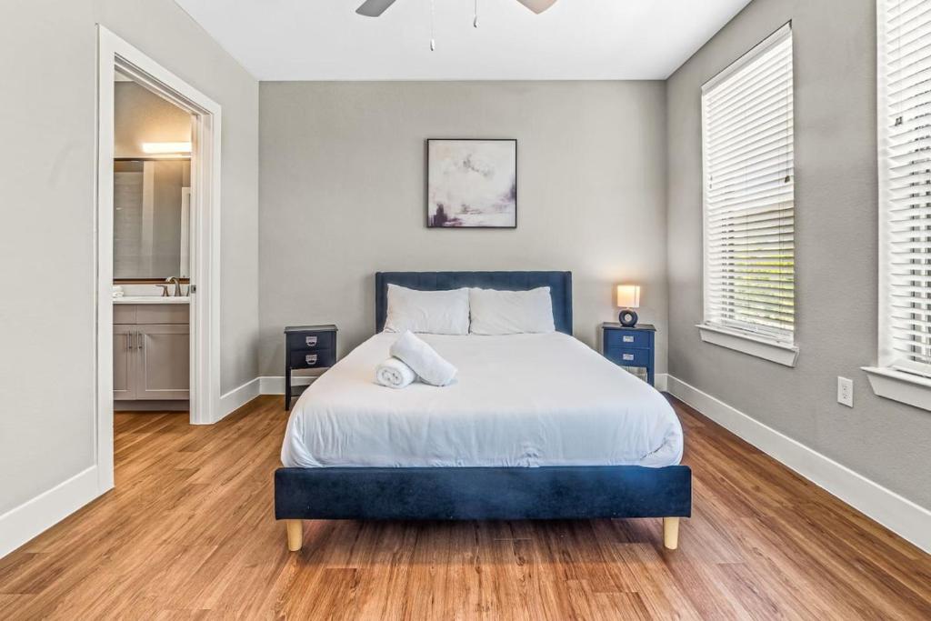 a bedroom with a large bed and two windows at Fascinating 2BD 2BA w Beautiful Pool in Fort Worth in Fort Worth