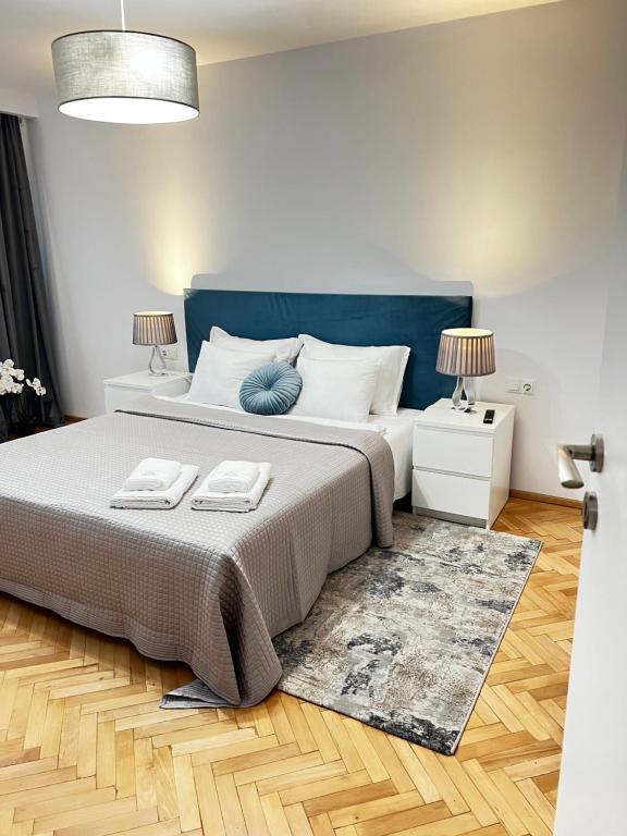 ein Schlafzimmer mit einem großen Bett mit blauem Kopfteil in der Unterkunft Atmosfera Sibiu in Sibiu