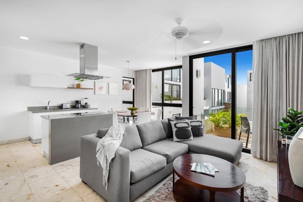 a living room with a couch and a kitchen at FEISIVA LUXURY Apartament in Playa del Carmen