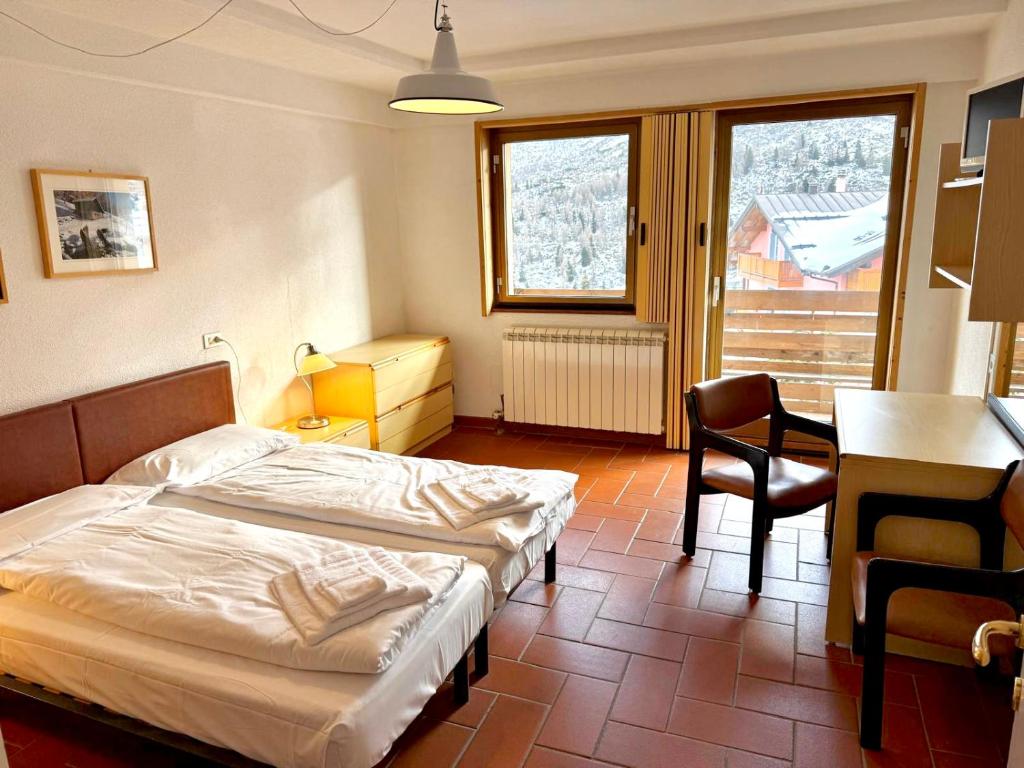 a bedroom with a bed and a desk and a table at Top Residence Bilocale Abete in Passo del Tonale
