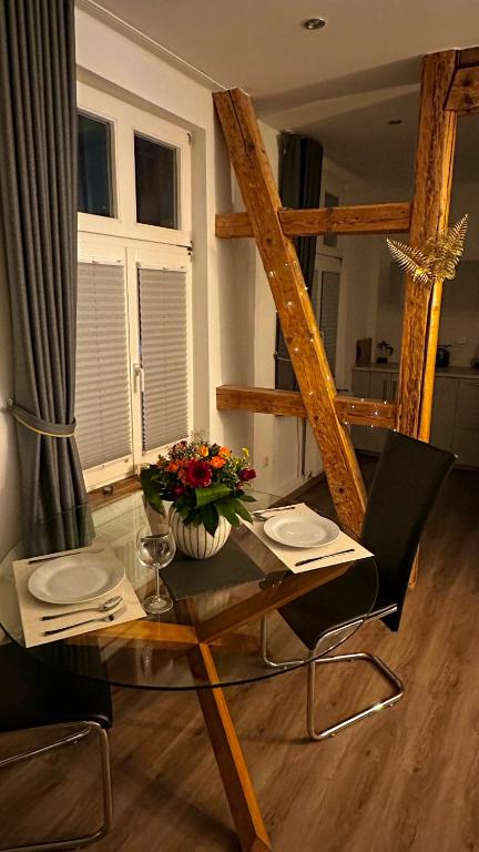 a glass table with a vase of flowers on it at Apartment Mauerblick in der Altstadt mit Smart TV Waschtrockner und voll ausgestatteter Küche in Goslar