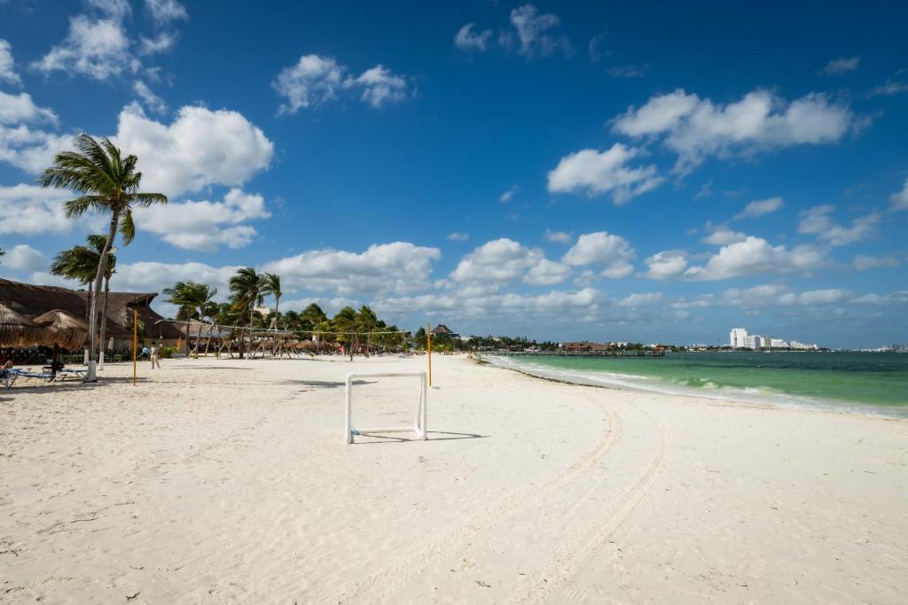 a beach with palm trees and the ocean at Villa oceanfront in hotel complex in Cancún