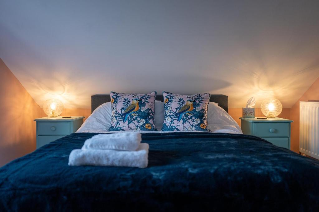 a bedroom with a bed with two lamps and towels at Family & Pet-Friendly Seaside Bungalow with Accessible Features in Minster