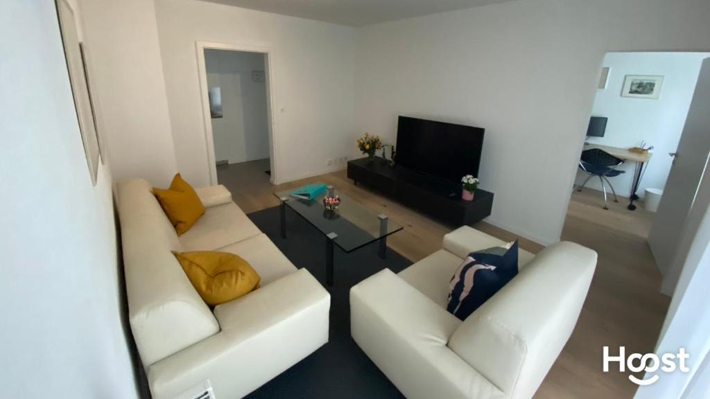ein Wohnzimmer mit zwei weißen Sofas und einem Fernseher in der Unterkunft H4 Family apartment, central, quite, modern in Zürich