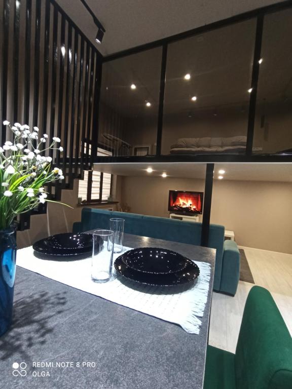 2 assiettes noires sur une table avec une cheminée dans l'établissement Двухуровневые апартаменты в ЖК Керемет на Каспийском море, à Aktau