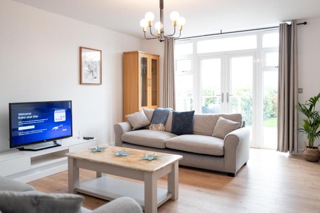 a living room with a couch and a tv at Family & Pet-Friendly Seaside Bungalow with Accessible Features in Minster
