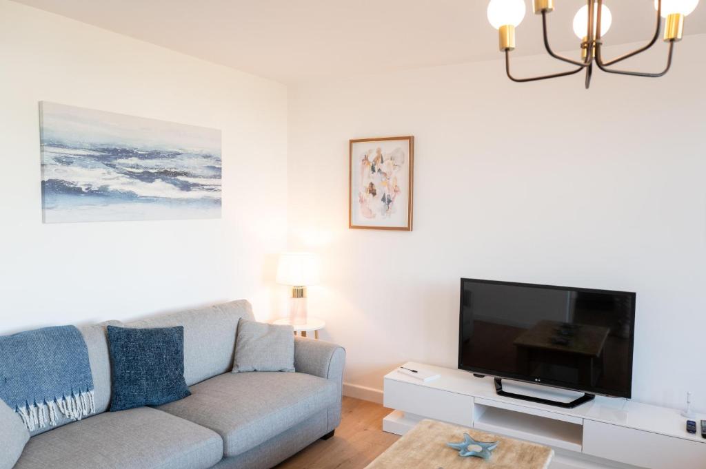 a living room with a couch and a flat screen tv at Family & Pet-Friendly Seaside Bungalow with Accessible Features in Minster