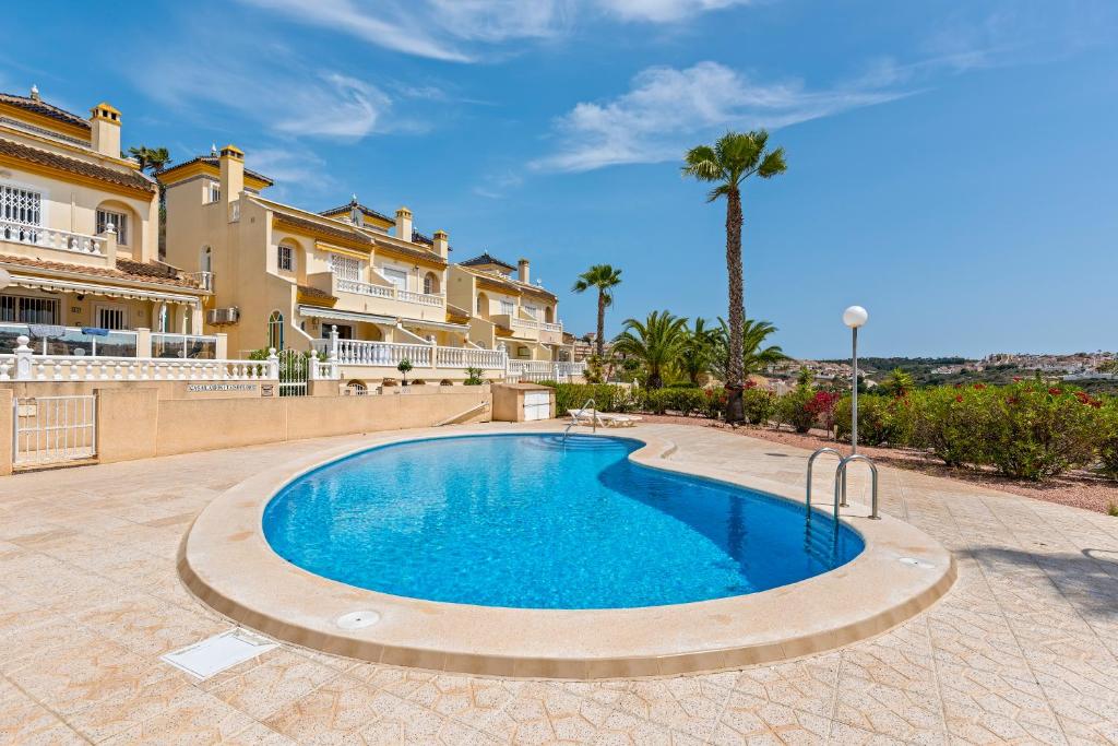 ein Swimmingpool vor einer Villa in der Unterkunft Ruime woning aan golfbaan in Rojales