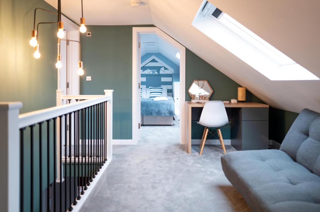 a room with a staircase with a blue couch and a desk at Family & Pet-Friendly Seaside Bungalow with Accessible Features in Minster