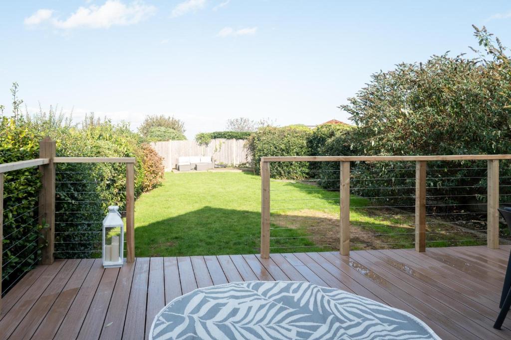 a wooden deck with a bed and a lantern at Family & Pet-Friendly Seaside Bungalow with Accessible Features in Minster