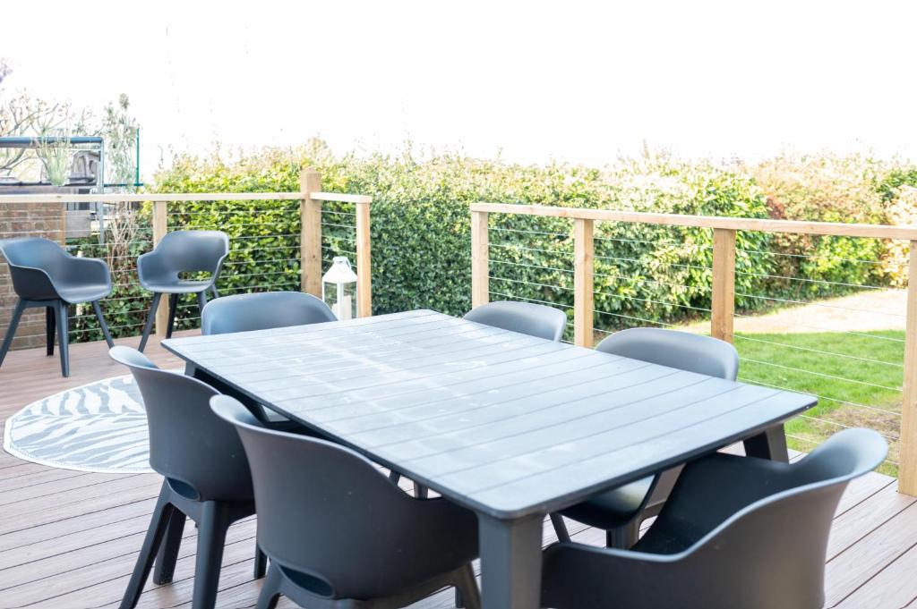 a blue table and chairs on a deck at Family & Pet-Friendly Seaside Bungalow with Accessible Features in Minster