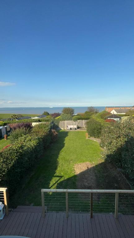 a deck with a bench and a view of the ocean at Family & Pet-Friendly Seaside Bungalow with Accessible Features in Minster