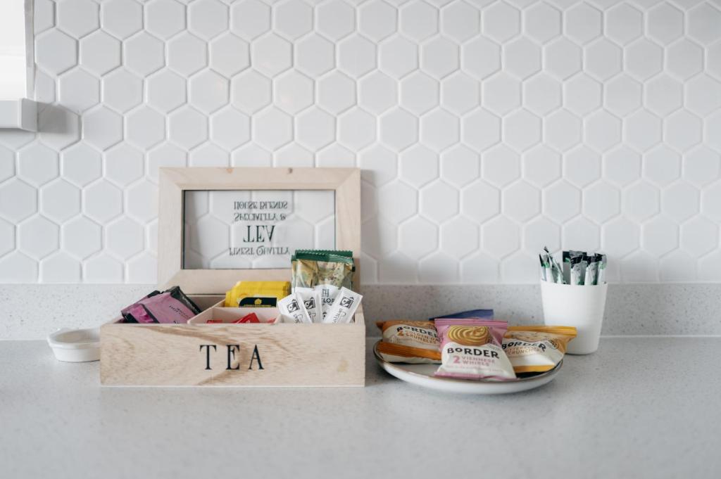 a box of tea sitting on a table with a plate at Family & Pet-Friendly Seaside Bungalow with Accessible Features in Minster