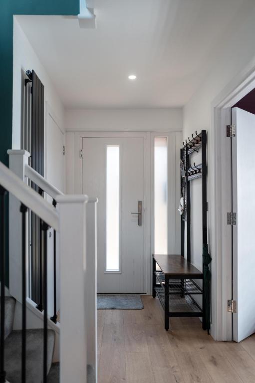 a hallway with a white door and a table at Family & Pet-Friendly Seaside Bungalow with Accessible Features in Minster