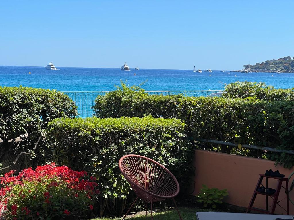 une chaise assise en face d'un jardin donnant sur l'océan dans l'établissement Le PAMELA face a la MER, à Menton