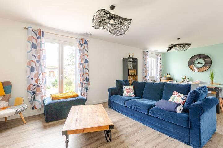 a living room with a blue couch and a table at La maison de Chassiron,Jacuzzi, Climatisation, 4 chambres, Plage à 600M in Chassiron