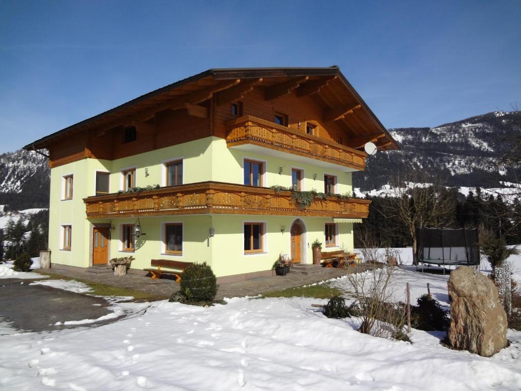 ein großes Haus im Schnee auf einem Berg in der Unterkunft Hinterlammerain in Abtenau