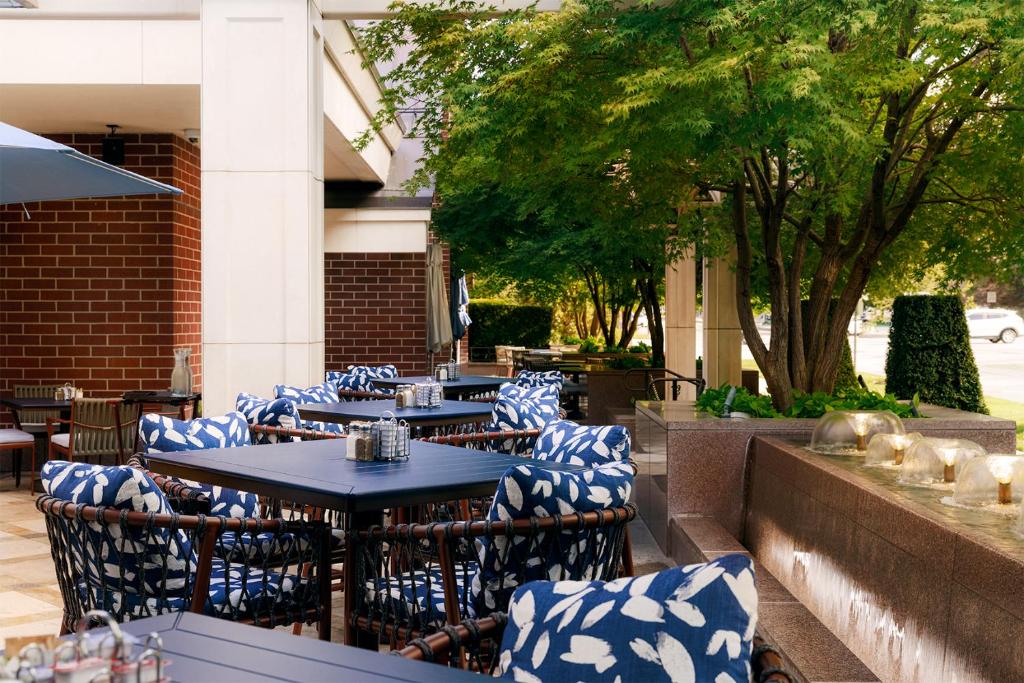 an outdoor patio with blue and white chairs and tables at Little America Hotel Salt Lake City in Salt Lake City