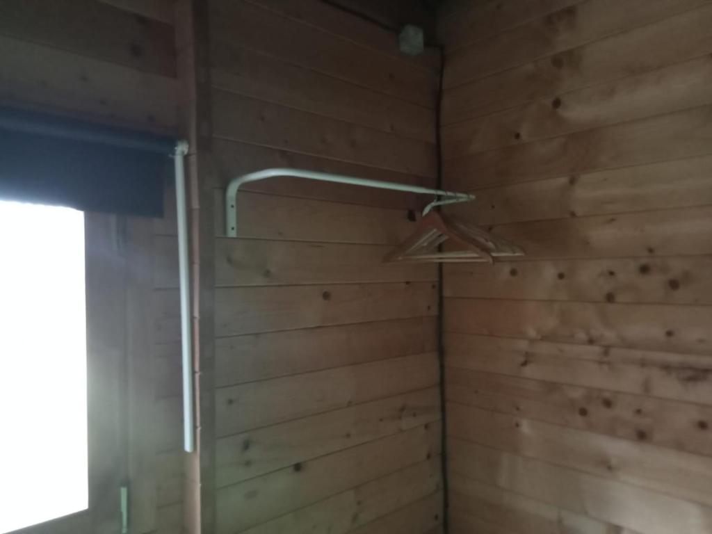Una ducha en una habitación con paredes de madera. en Surf Camp Ecológico, en Costa da Caparica