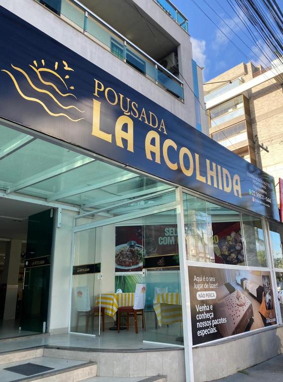 una tienda con un cartel azul y amarillo en un edificio en Pousada La Acolhida, en Cabo Frío
