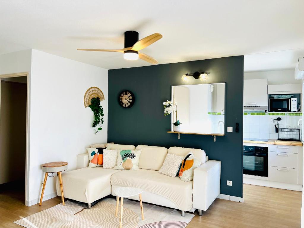 - un salon avec un canapé blanc et un miroir dans l'établissement Appartement T3 de 52 mcarré à Muret, à Muret