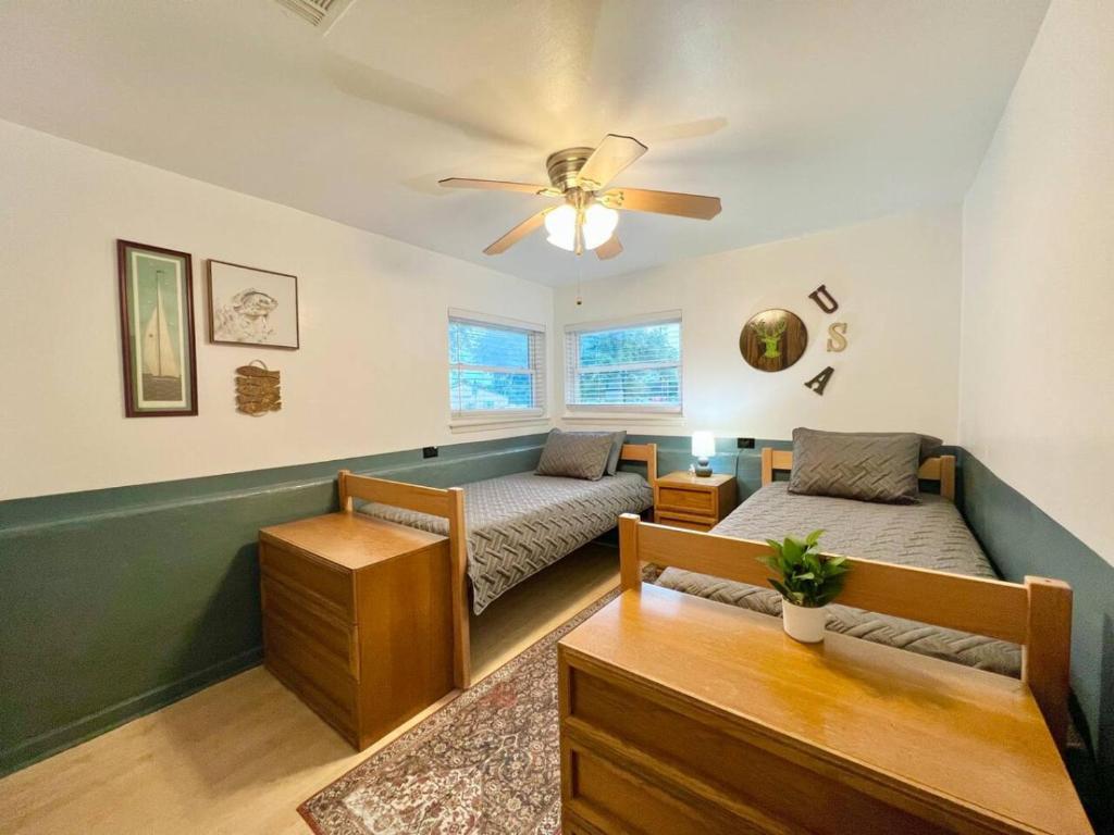 ein Schlafzimmer mit zwei Betten und einem Deckenventilator in der Unterkunft Lake Life Lodge Cottage by Belton Lake in Belton