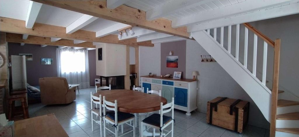 une cuisine et une salle à manger avec une table et un escalier dans l'établissement SP270-001 Maison 4 pièces SAINT PIERRE LA MER, à Saint Pierre La Mer