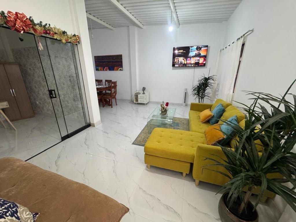 a living room with a yellow couch and a glass table at LA CASA de DERY EN MANCORA in Máncora