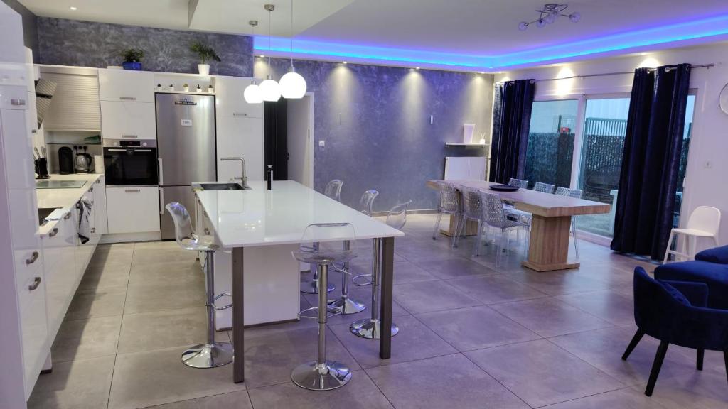 a kitchen and dining room with white appliances and tables at Villa T5 proche centre ville in Aix-les-Bains