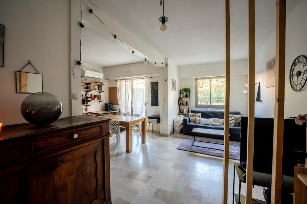 un salon avec une cuisine et un salon avec une table dans l'établissement T2 Cosy proche du centre avec grande terrasse!, à Nîmes