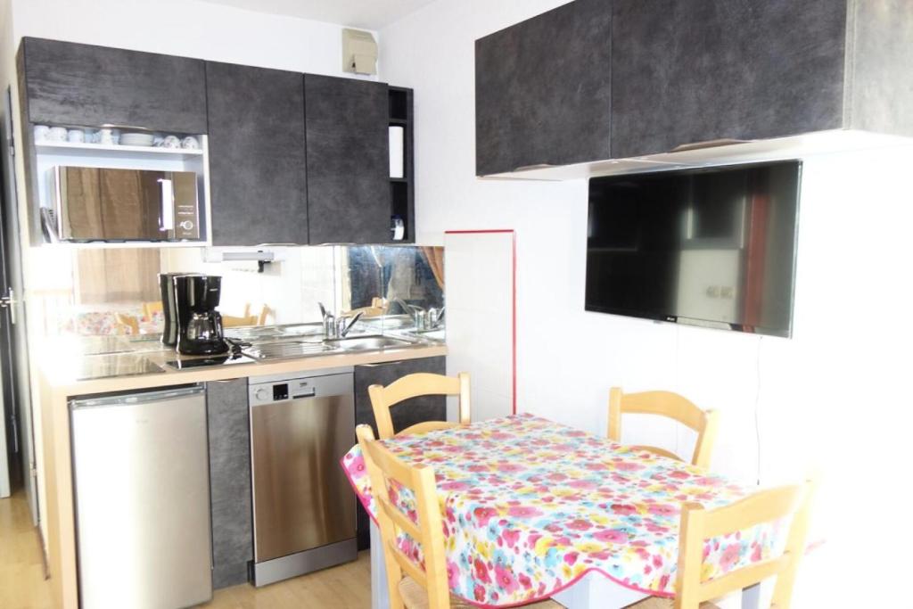 une petite cuisine avec une table et des chaises. dans l'établissement Résidence Portes D'huez - APPARTEMENT ALPE DHUEZ QUARTIER PASSEAUX MAE-9311, à Huez