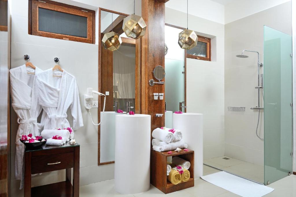 a bathroom with a walk in shower and a shower stall at Tulia Zanzibar Unique Beach Resort in Pongwe