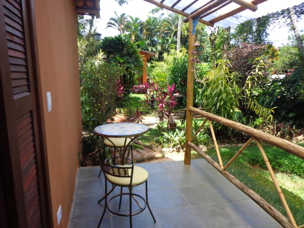 a patio with a table and chairs on a porch at Pousada Canto Bella Terra in Ilhabela
