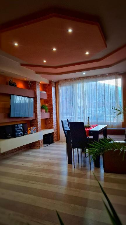 a living room with a dining table and a television at Стаи за гости Върбите in Sapareva Banya
