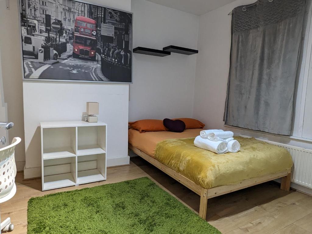 a small bedroom with a bed and a green rug at Lovely studio flat in Hackney Clapton in London