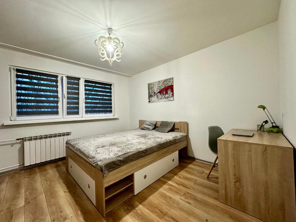 sypialnia z łóżkiem, biurkiem i oknem w obiekcie Apartament Wieluńska w Warszawie