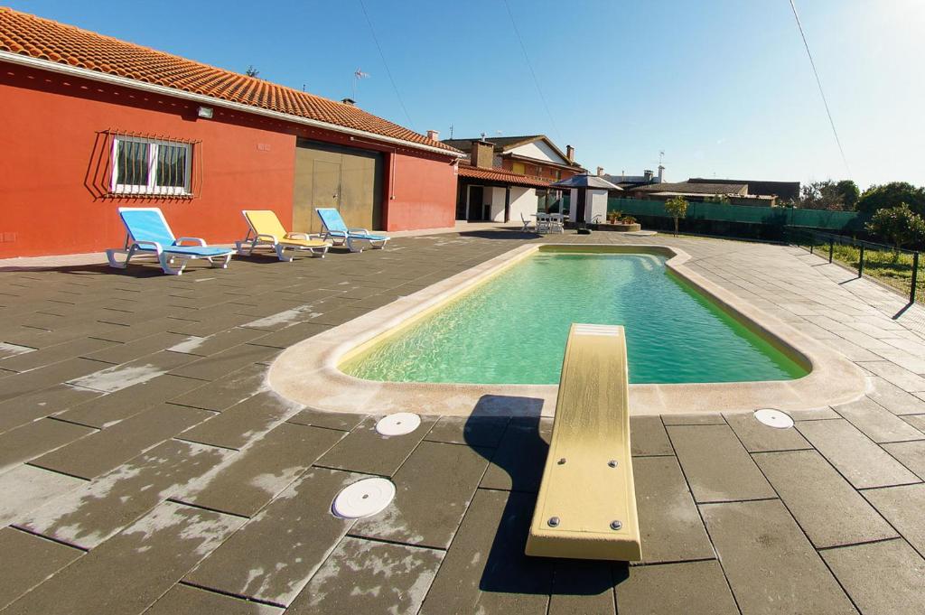 a swimming pool with a bench next to a house at Casa do Avo Louro in Covões