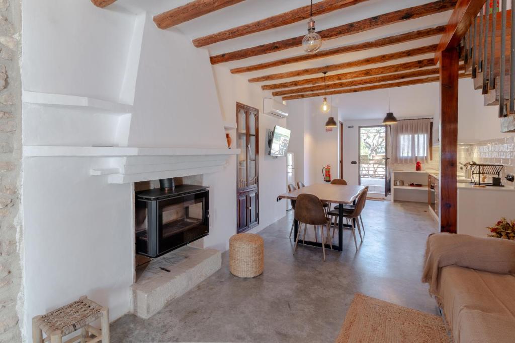 a living room with a table and a fireplace at Casa Rural Mas dels Fumeros in Useras