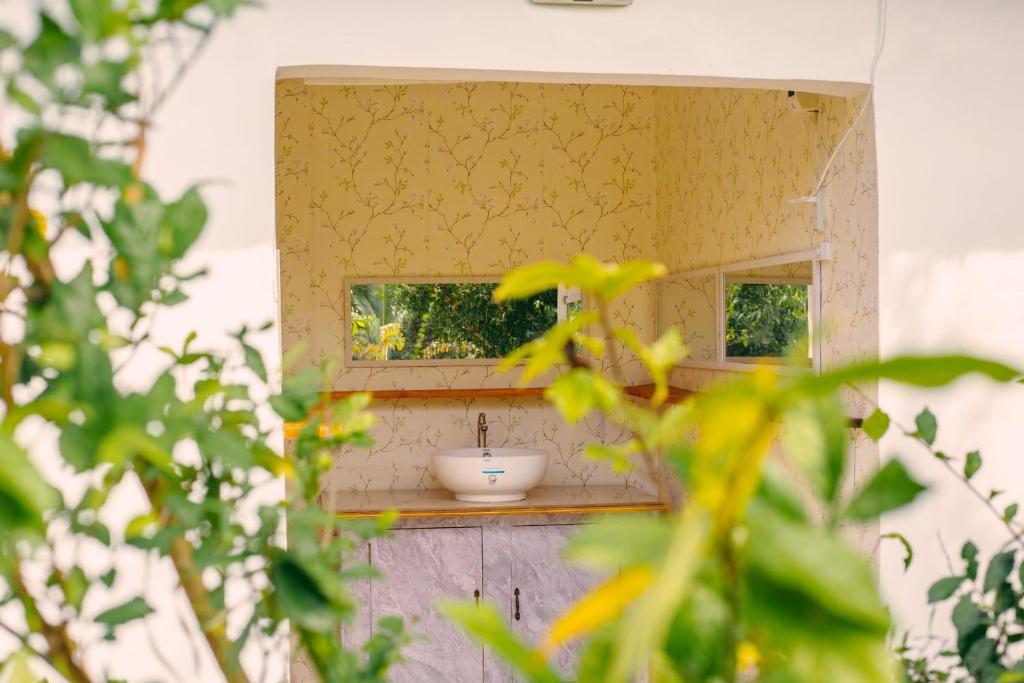 a bathroom with a sink and a mirror at Green Acres Village Cabin Rental with Air conditioner in Moalboal