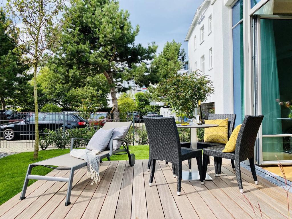 a patio with chairs and a table on a deck at Ferienwohnung Luxus Sonnensuite in der Strandvilla Charlotte Binz in Binz