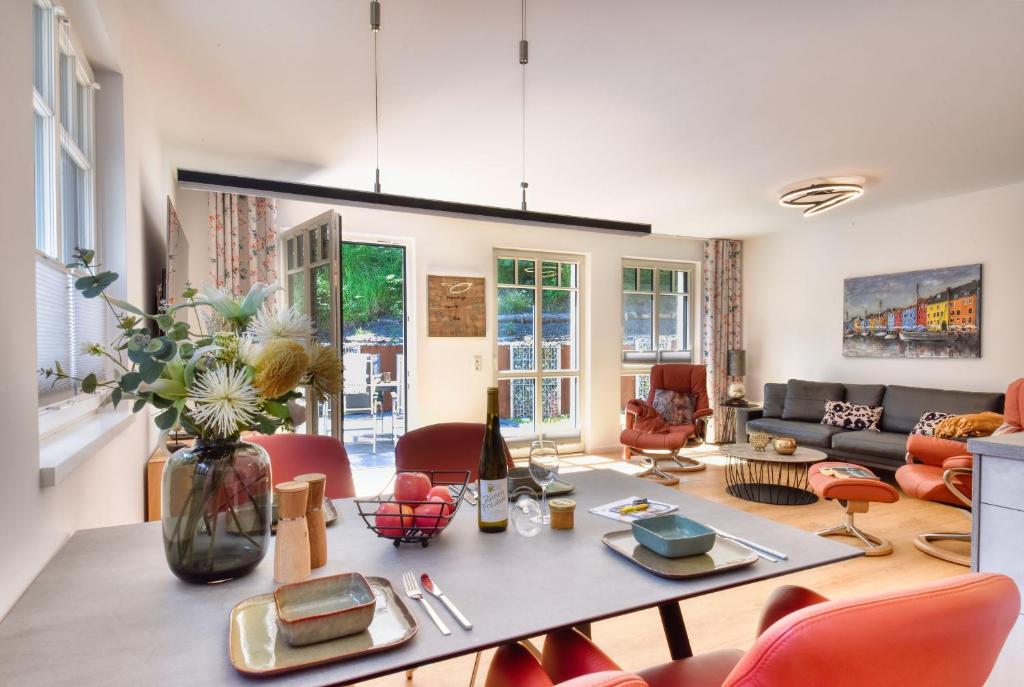 een woonkamer met een tafel en rode stoelen bij Ferienwohnung Meereslauschen in der Villa Beatrice in Binz